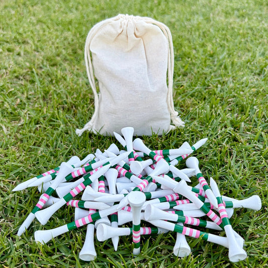 Level Pegs Tee Club: a cotton pouch and 50 white bamboo golf tees with pink and green stripes on the grass